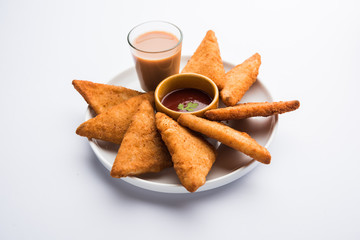 crispy Potato triangles or batata vada covered with bread crumbs and then deep fried. served with tomato ketchup. selective focus