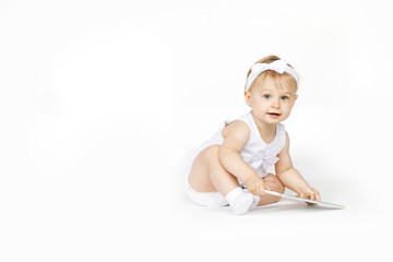 little girl all in white with a tablet