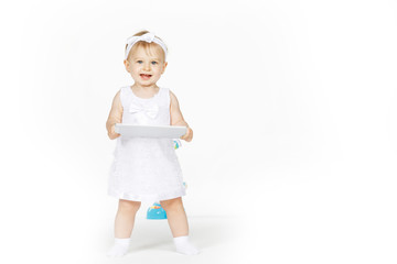 little girl all in white with a tablet