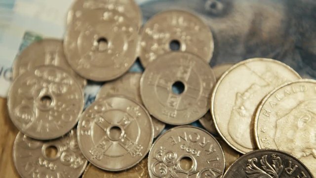 Detail of a pile of Norwegian kroner coins, panning right shot