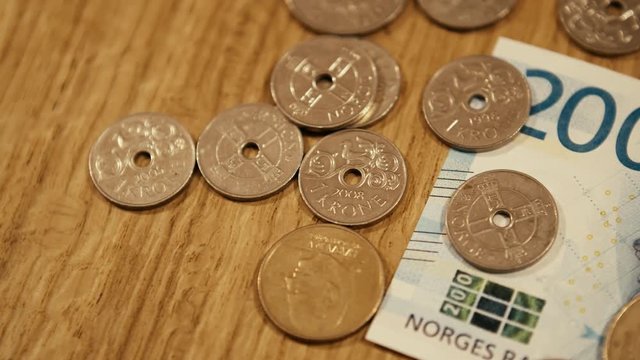 Norwegian Kroner Coins on top of a 200 Kroner bill. Panning left shot
