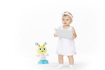 little girl all in white with tablet and toy