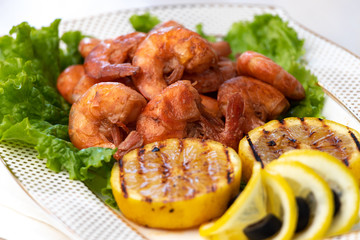 Grilled prawns with lemon grill on white plate