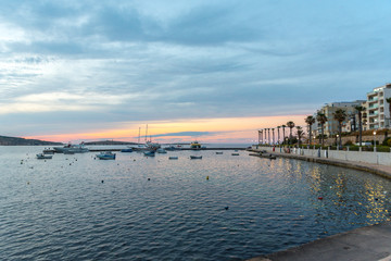 The panorama of harbour on St Paul's Bay with fishing boats and tourist ships, Bugibba, Malta