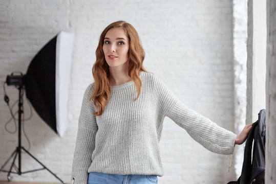 Portrait of young atrractive redhead woman photographer in studio