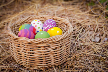 Many colorful Easter eggs, beautiful designs on the hay in the basket.  festival