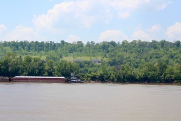 A barge parked on the shore of the river on a sunny day.