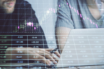Forex graph with businessman typing on computer in office on background. Concept of analysis. Double exposure.