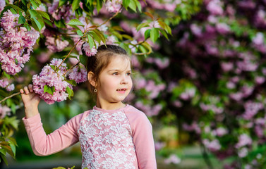 New Life. happy girl in cherry flower. Sakura tree blooming. small girl child in spring flower bloom. skincare spa. Natural cosmetics for skin. blossom smell, allergy. summer. Childhood beauty