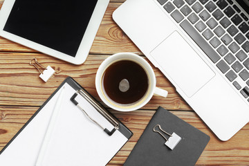 Wooden office desk table and equipment for working with black coffee in angle view