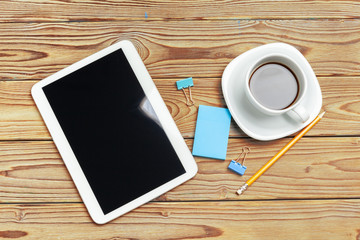 Work space. Digital tablet and coffee cup with supplies, still life