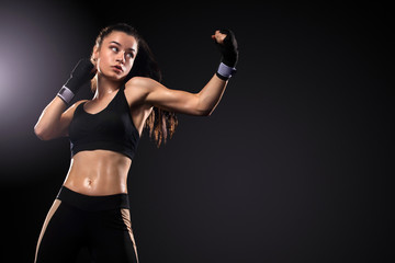 Sportsman, woman boxer fighting in gloves on black background. Boxing and fitness concept.