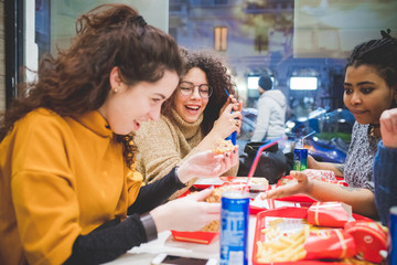 group of girlfriends eating diner in fast food
