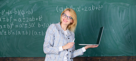 Learn it easy way. Woman teacher wear eyeglasses holds laptop surfing internet. Educator smart...