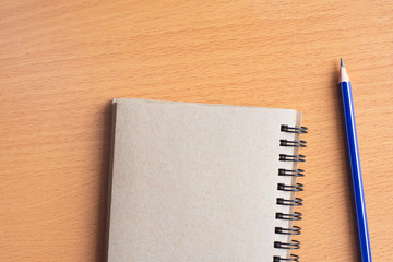 Notepad with pencil on wood board background.using wallpaper for education, business photo.Take note of the product for book with paper and concept, object or copy space.
