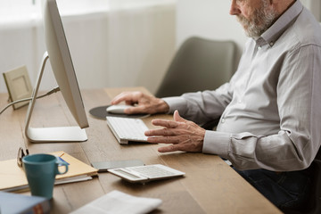 Senior man using his computer at home