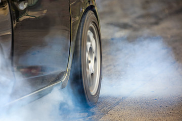 Front wheel drive drag race car burning tires at starting line