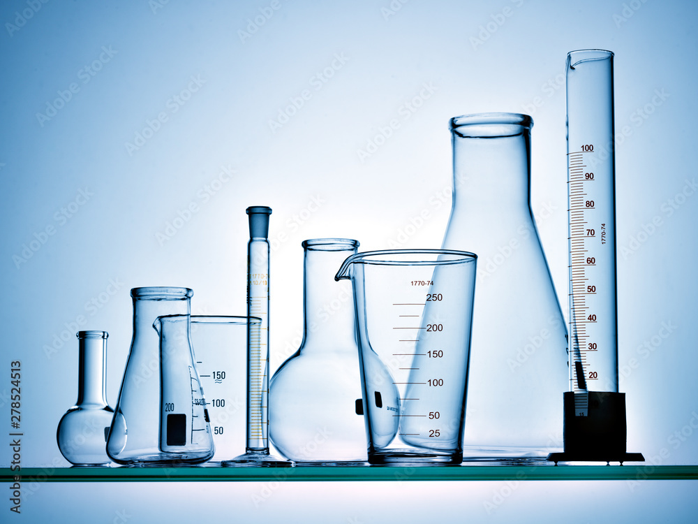 Wall mural different laboratory glassware with liquid and with reflection