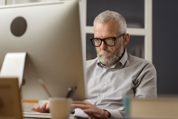 Senior man connecting with his computer at home