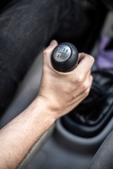 Detalle de mano cambiando de marchas mientras conduce un coche