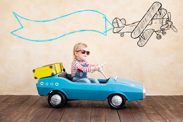 Funny kid driving toy car indoor.