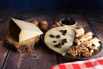 Slices and piece of traditional Spanish Manchego cheese and nuts