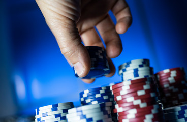Naklejka premium Successful man stacking poker chips at the casino