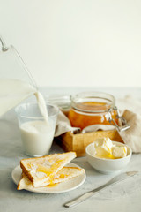 A stack of delicious toast with butter  and glass of milk for Breakfast on the morning table.Healthy breakfast food concept.A stylish breakfast prepared on a light table close-up with space for text