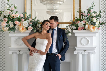 groom embraces bride from behind in beautiful pose. proximity of newlyweds. Relationship in family....