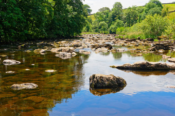 Fototapeta na wymiar Rocks and boulders litter the River Ribble near Stainforth