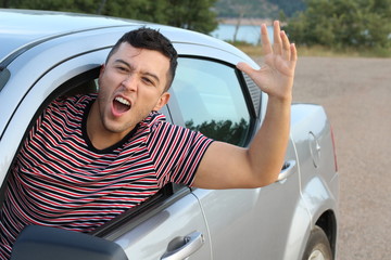 Angry young man driving a car