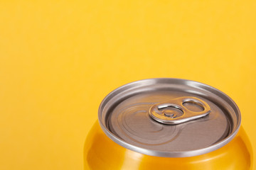 Yellow aluminum can on color background with space for text