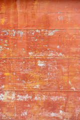 orange paint peeling off old metal strips. Old Metallic patchwork orange. Metal panels are peeling off paint. old metal sheets