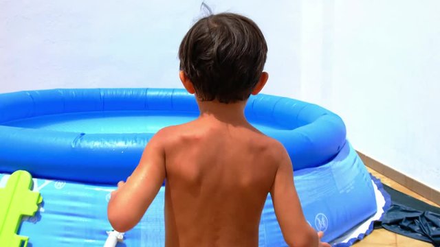 little kid jumping into cheap plastic pool