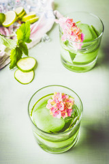 Glass of green iced cucumber rosemary drink. refreshing drink with ice. Infused water . Healthy summer beverages . Homemade lemonade with fresh herbs