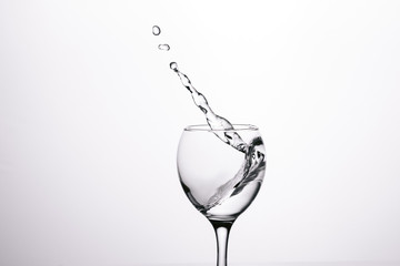 splash of water in wineglass isolated on white background.