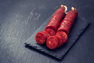 spanish smoked sausage chorizo on black ceramic board