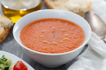 typical spanish cold spup gazpacho in white bowl on cermic background