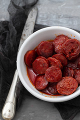 typical spanish sausage chorizo in white bowl on ceramic background