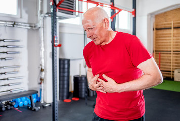 Fototapeta na wymiar Senior man at the gym suffering from heart attack