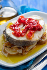 boiled fish with vegetables, olive oil in dish on blue wooden background