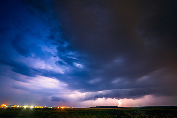 A severe thunderstorm is illuminated by a lightning bolt at night in Lithuania