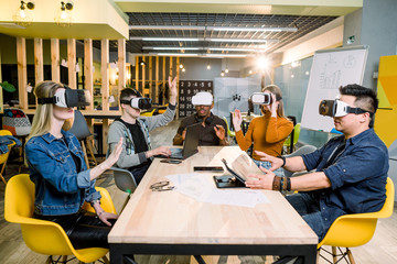 Young happy friends testing video games wearing virtual reality glasses indoors - Cheerful people having fun with new trends technology - Gaming concept