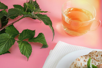 Fried pancakes close-up on a white plate, pancakes with raspberries, tea cerimonia, dessert on a pink background