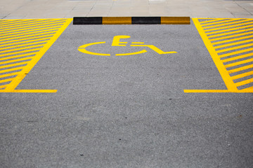 Handicapped parking spot. Parking place reserved for disabled people. Handicap symbol on road