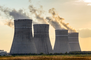 Sunset at atomic power plant. View at Cooling tower emitting vapor. Ukrainian Atomic station.