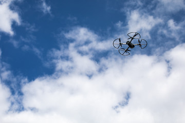 drone quadcopter with digital camera on blue sky background