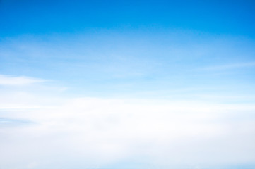 Fototapeta premium The blue summer sky with white fluffy clouds. Photo from window on the airplane.