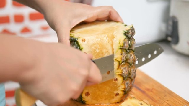 Peeling a pineapple on the cutting board