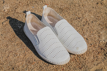 white slippers on the yellow sand under the scorching sun